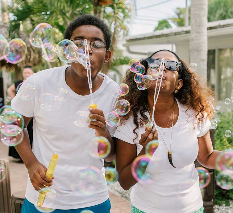 two people blowing bubbles outdoors